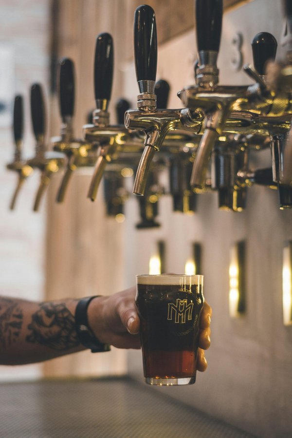 How should a bar approach the introduction of a new craft beer to its regular patrons?